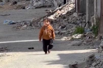 Gazze'de yıkıntıların arasında yalın ayak yürüyen çocuk görüntülendi